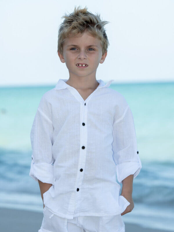 Boy on beach with white top